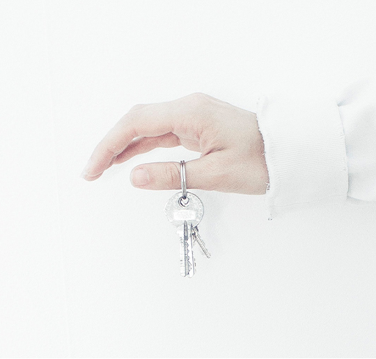 about_closed_escrow white hand holding house keys